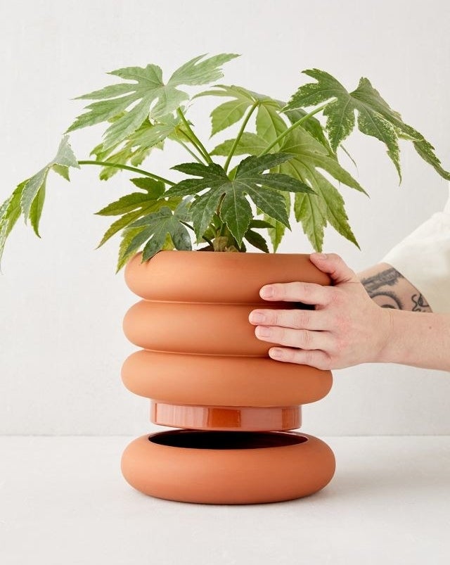 Person stacking the planter