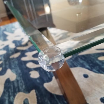 reviewer's photo of a clear guard placed on a glass table corner