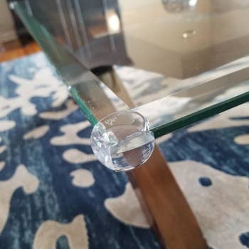 reviewer's clear guard placed on a glass table corner