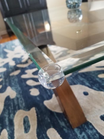 reviewer's photo of a clear guard placed on a glass table corner