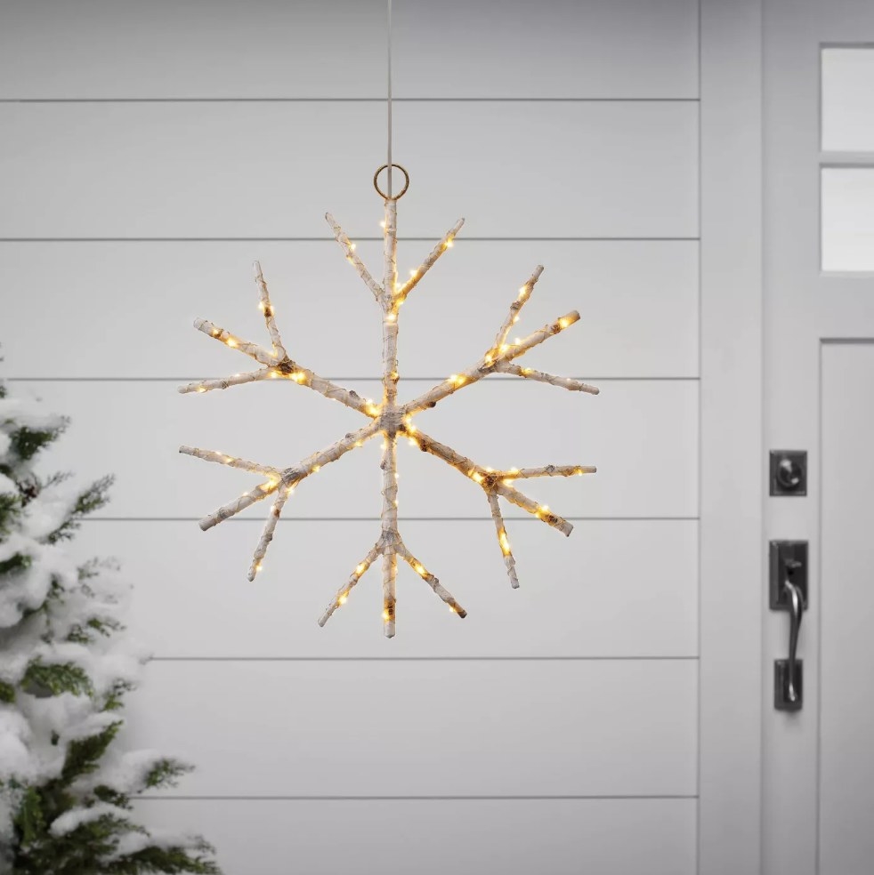 Birch twig hanging snowflake light outside of white house