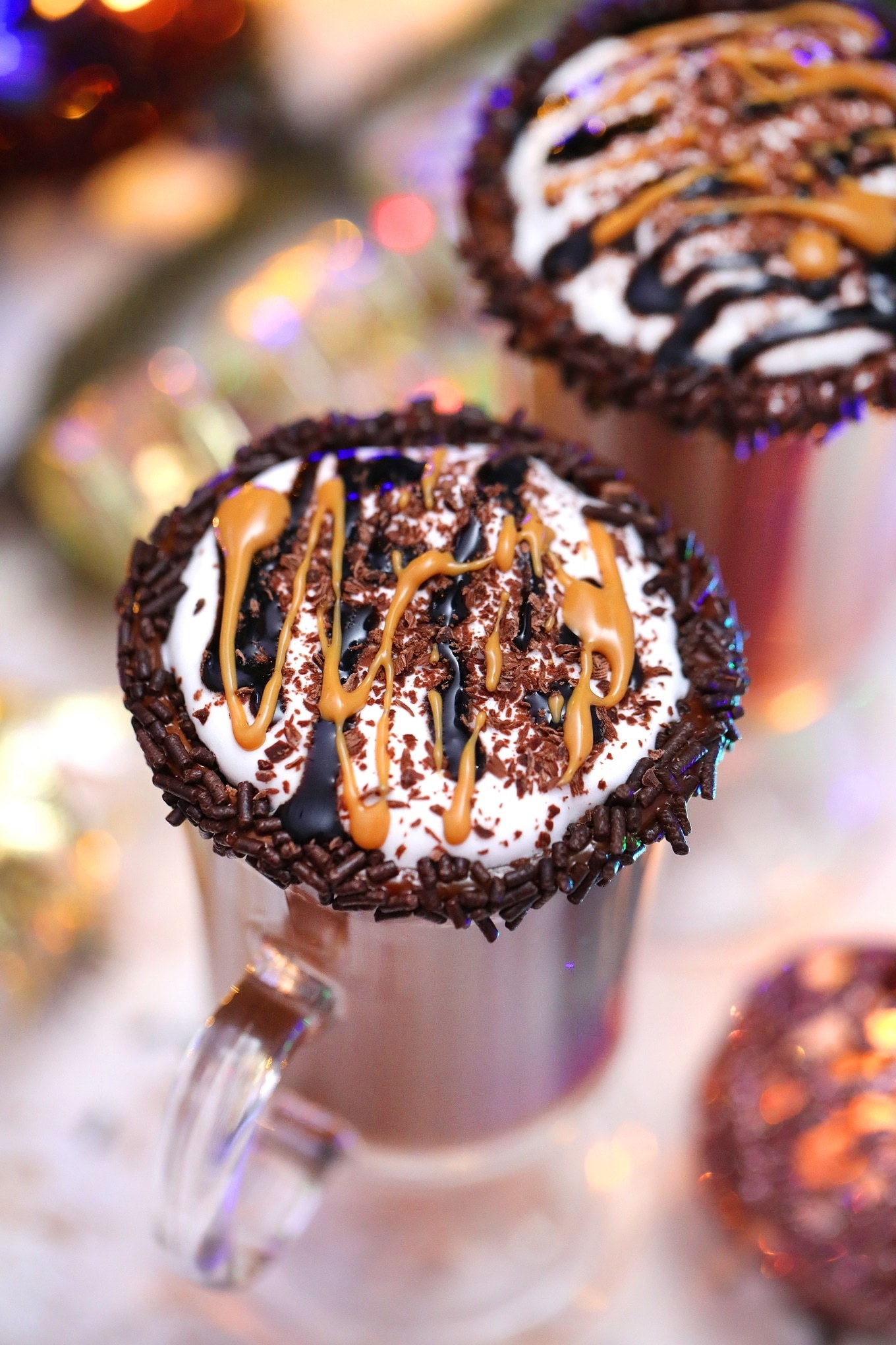 two cups of hot chocolate with peanut butter and chocolate drizzle