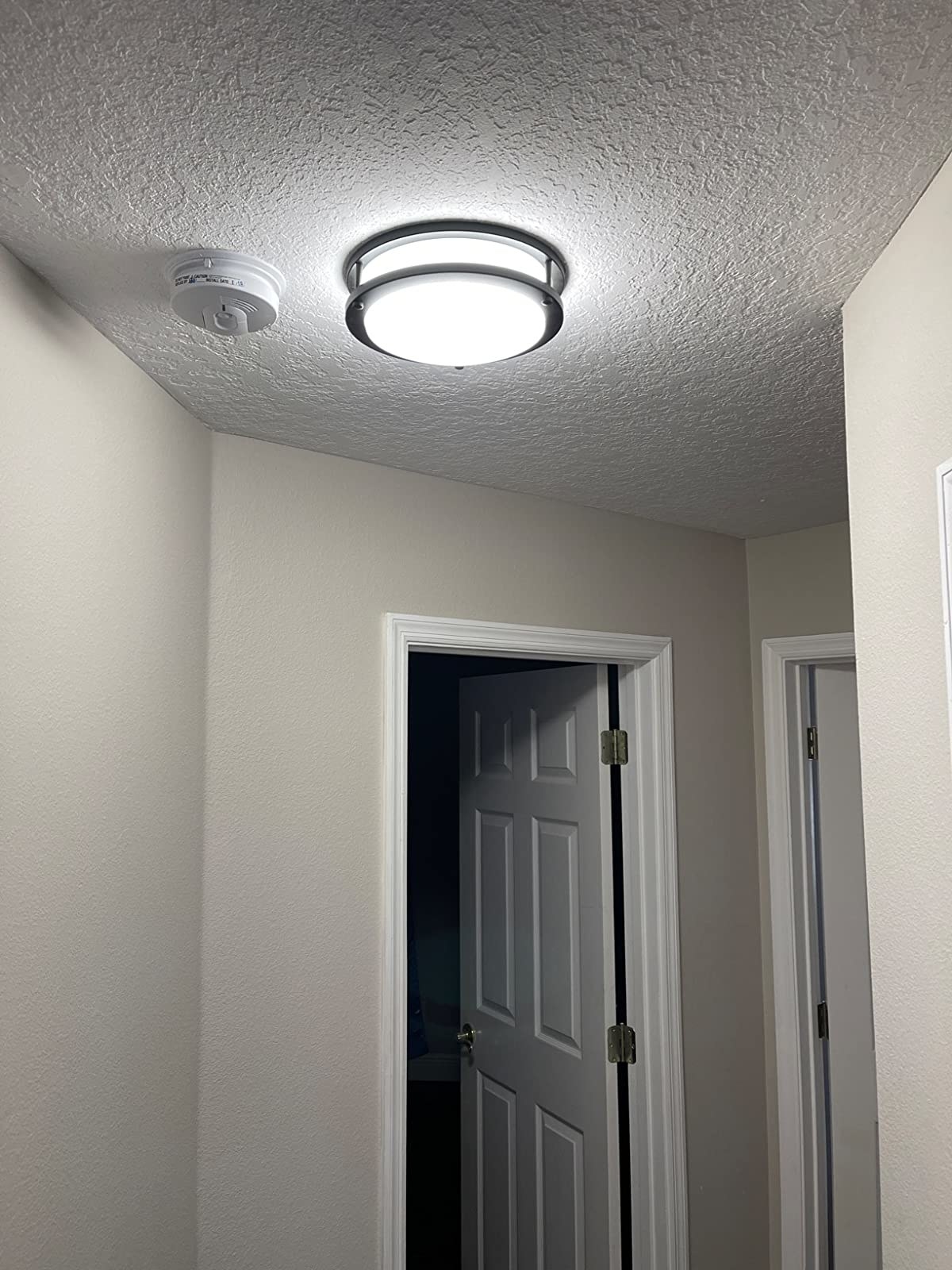 A ceiling mounted LED light brightening up a dark hallway