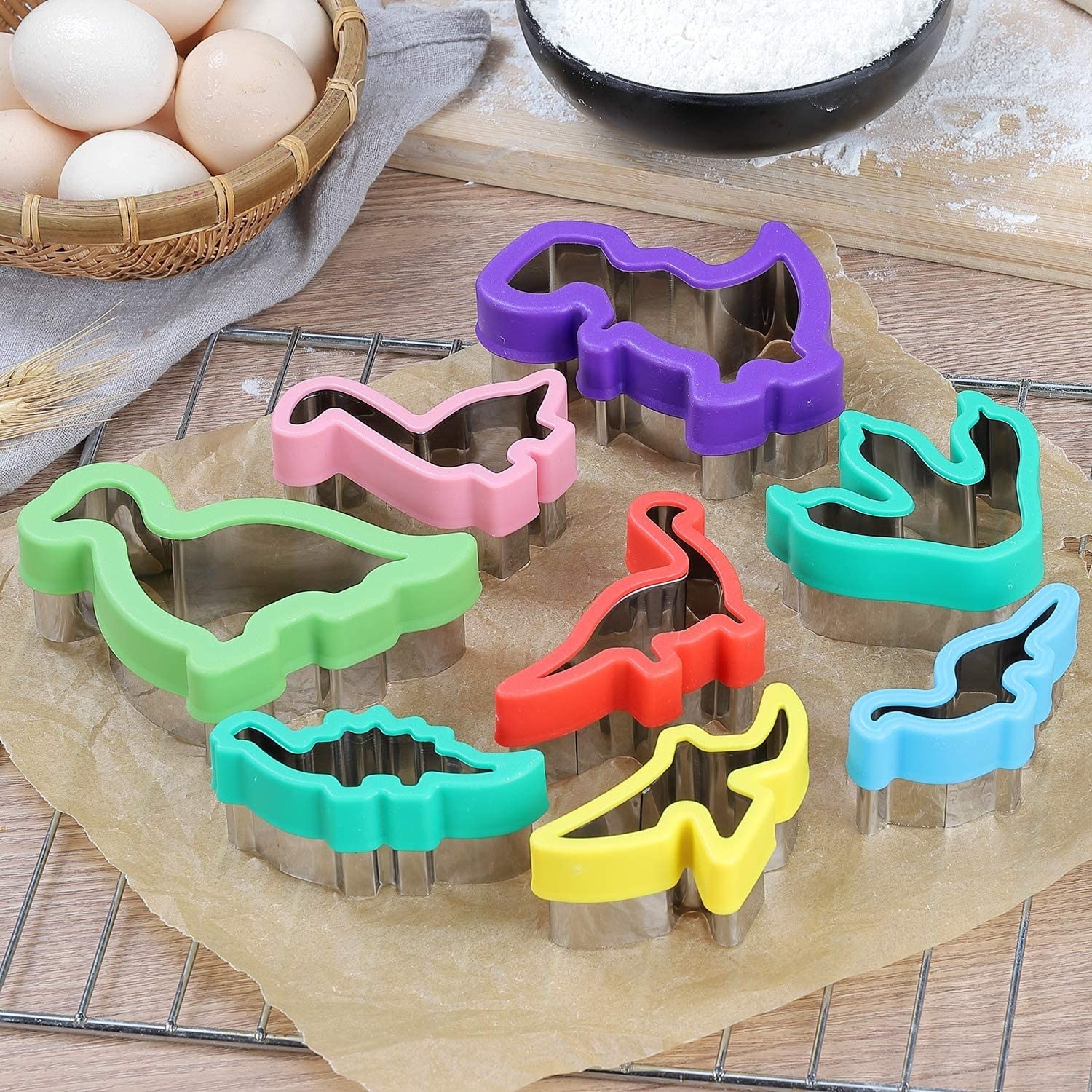 The dino cookie cutters on a sheet of parchment paper