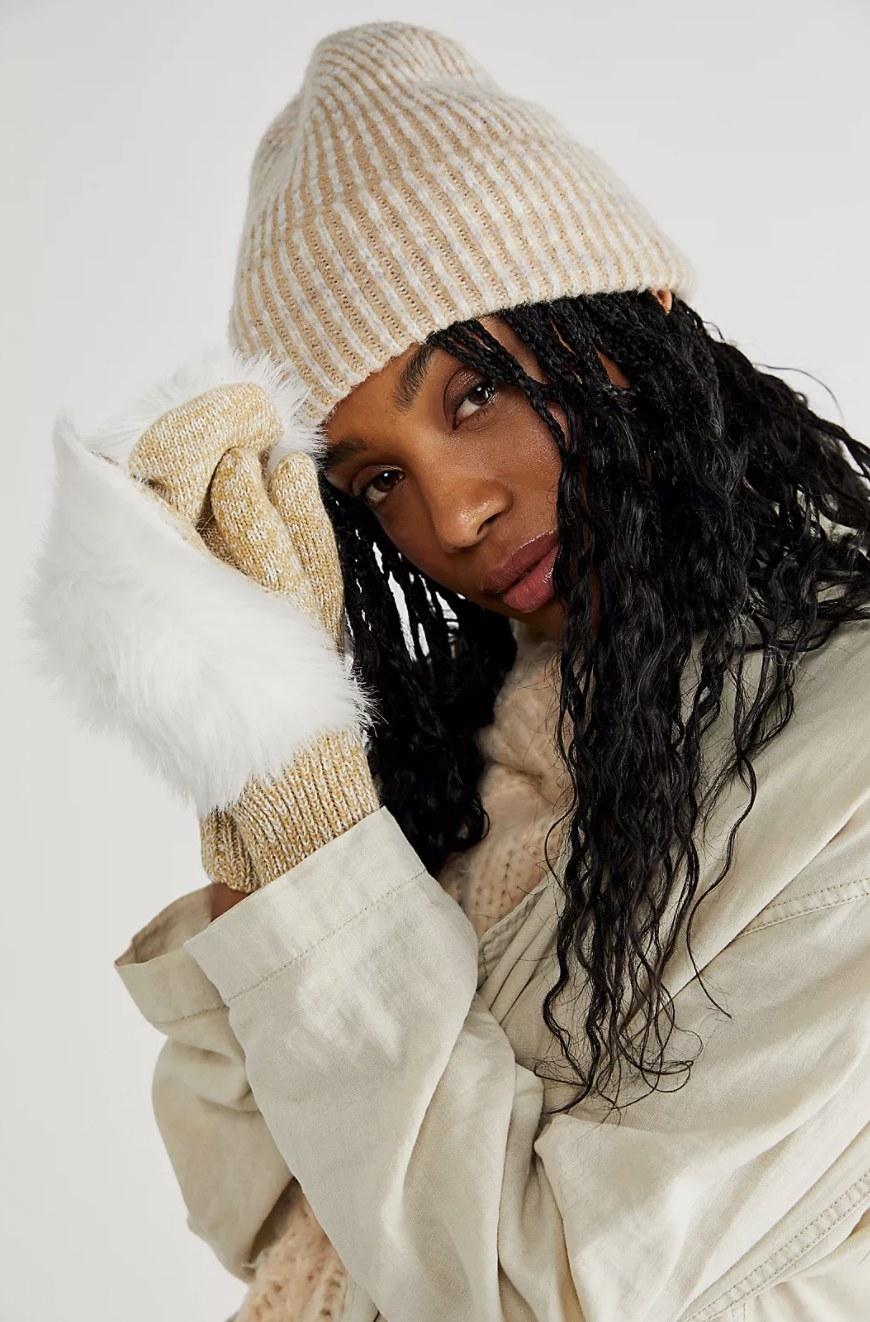 Model wearing the beige and white faux fur mittens