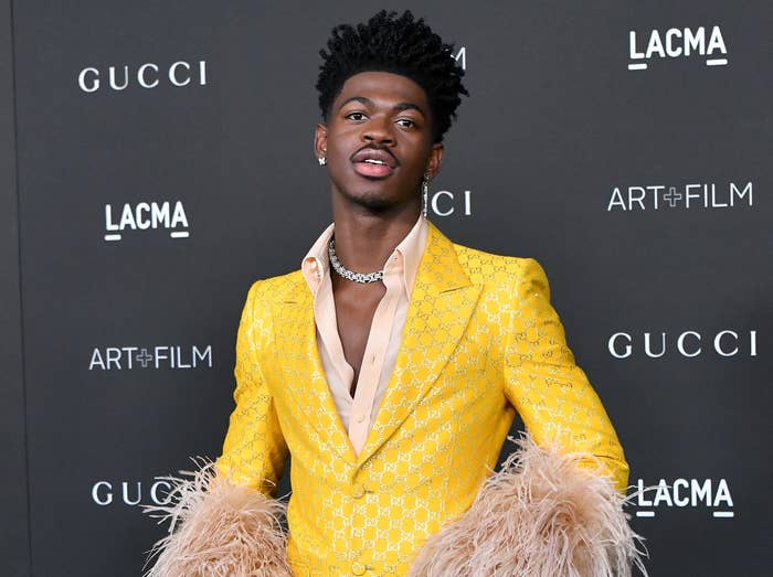 A closeup of lil nas x wearing a yellow suit