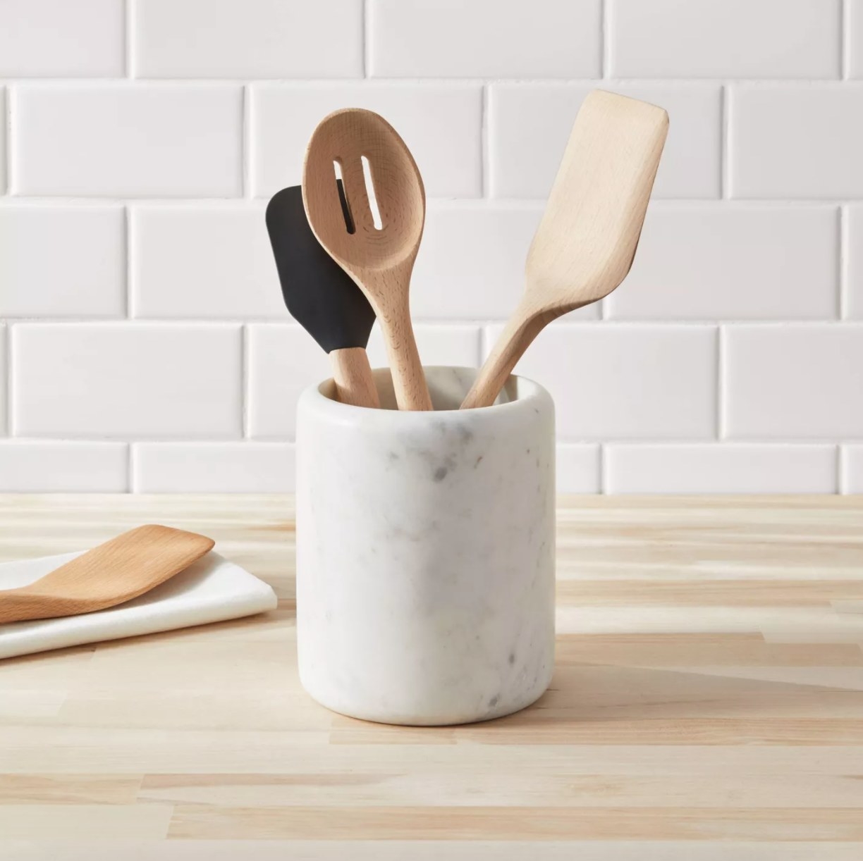 white and gray marble utensil holder with spatula and other utensils