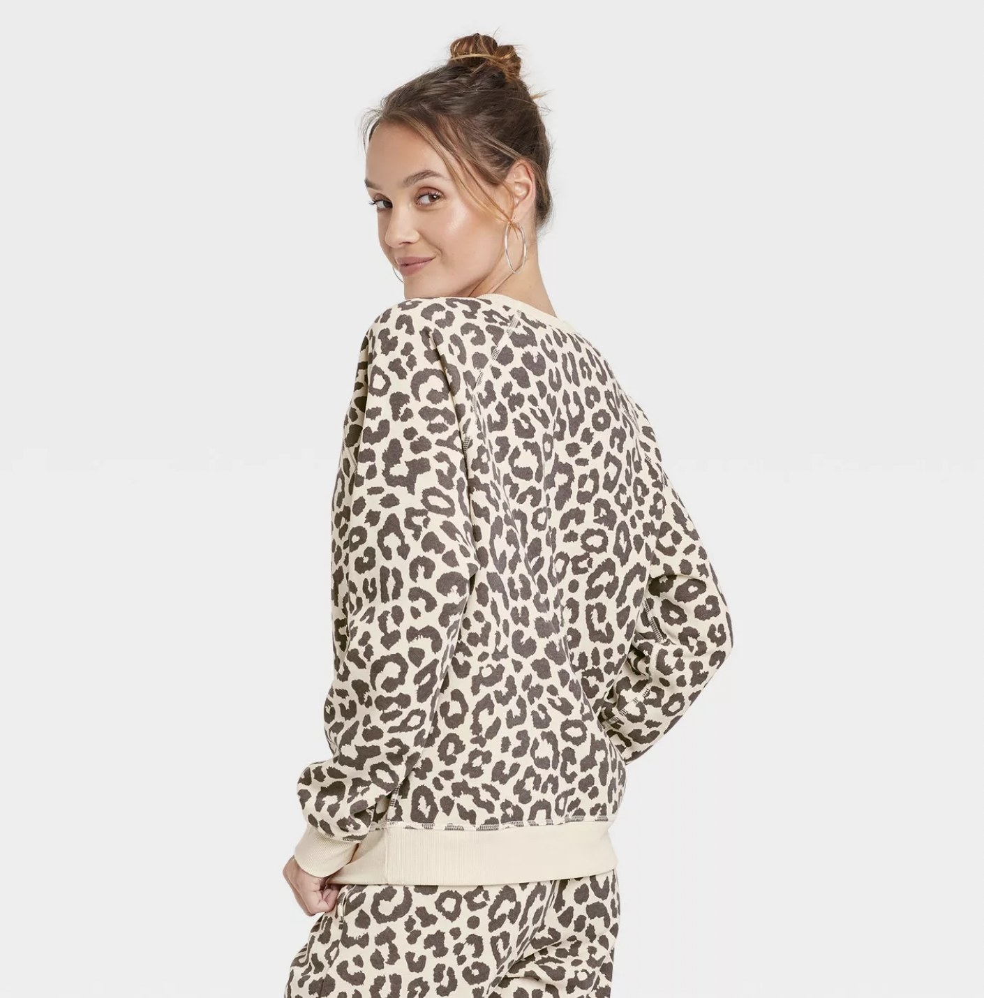 Model wearing the cheetah-print crewneck sweatshirt