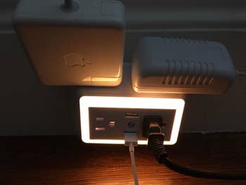 A different reviewer's night light charger with several different cords plugged in