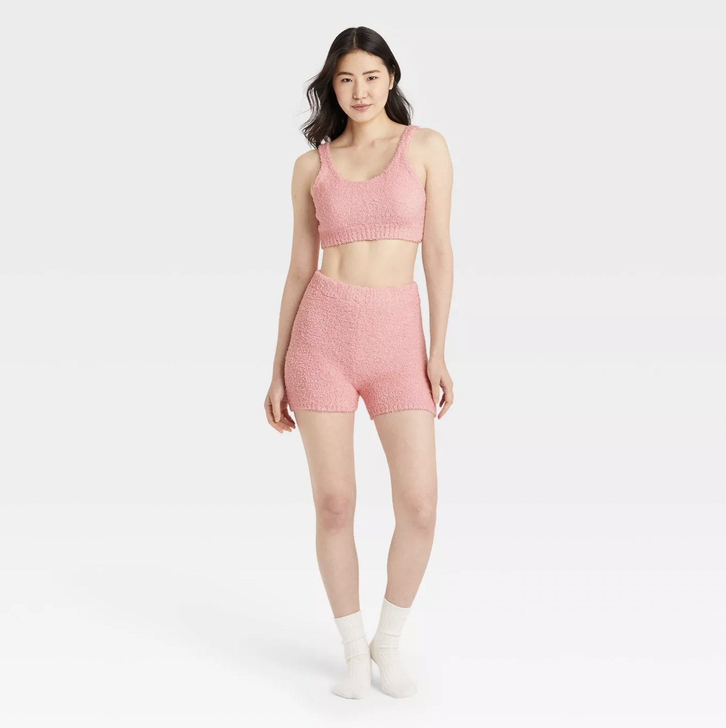 Model wearing the pink lounge shorts with matching crop top