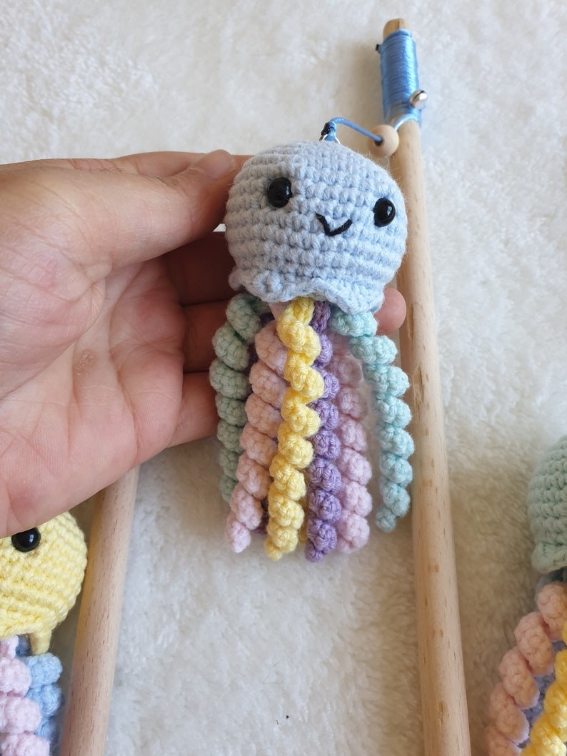 a hand holding one of the crocheted octopuses