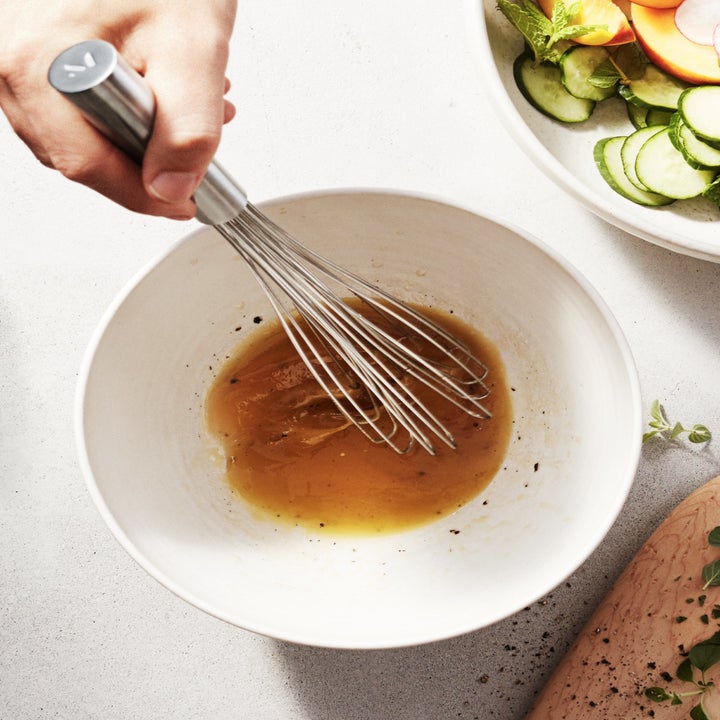 person using air whisk to make a dressing