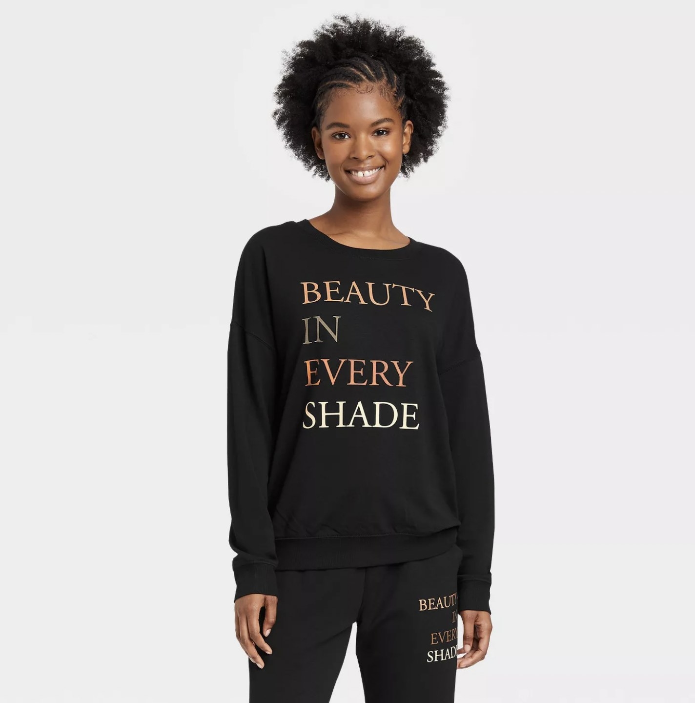 Model in the black crewneck sweatshirt with the message in colored capital letters