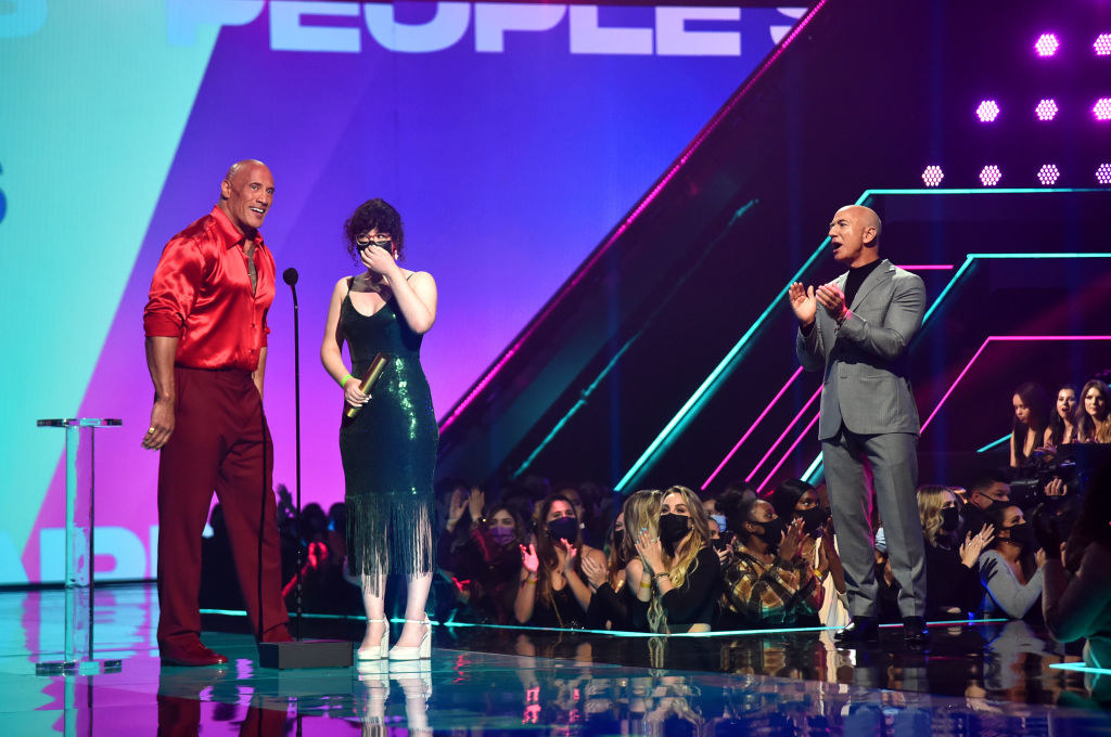 Shusan onstage in a beautiful fringe dress next to The Rock