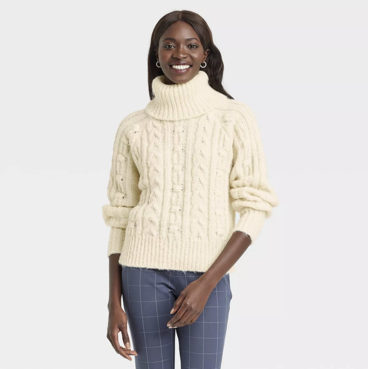 Model in the cream-colored mock turtleneck sweater