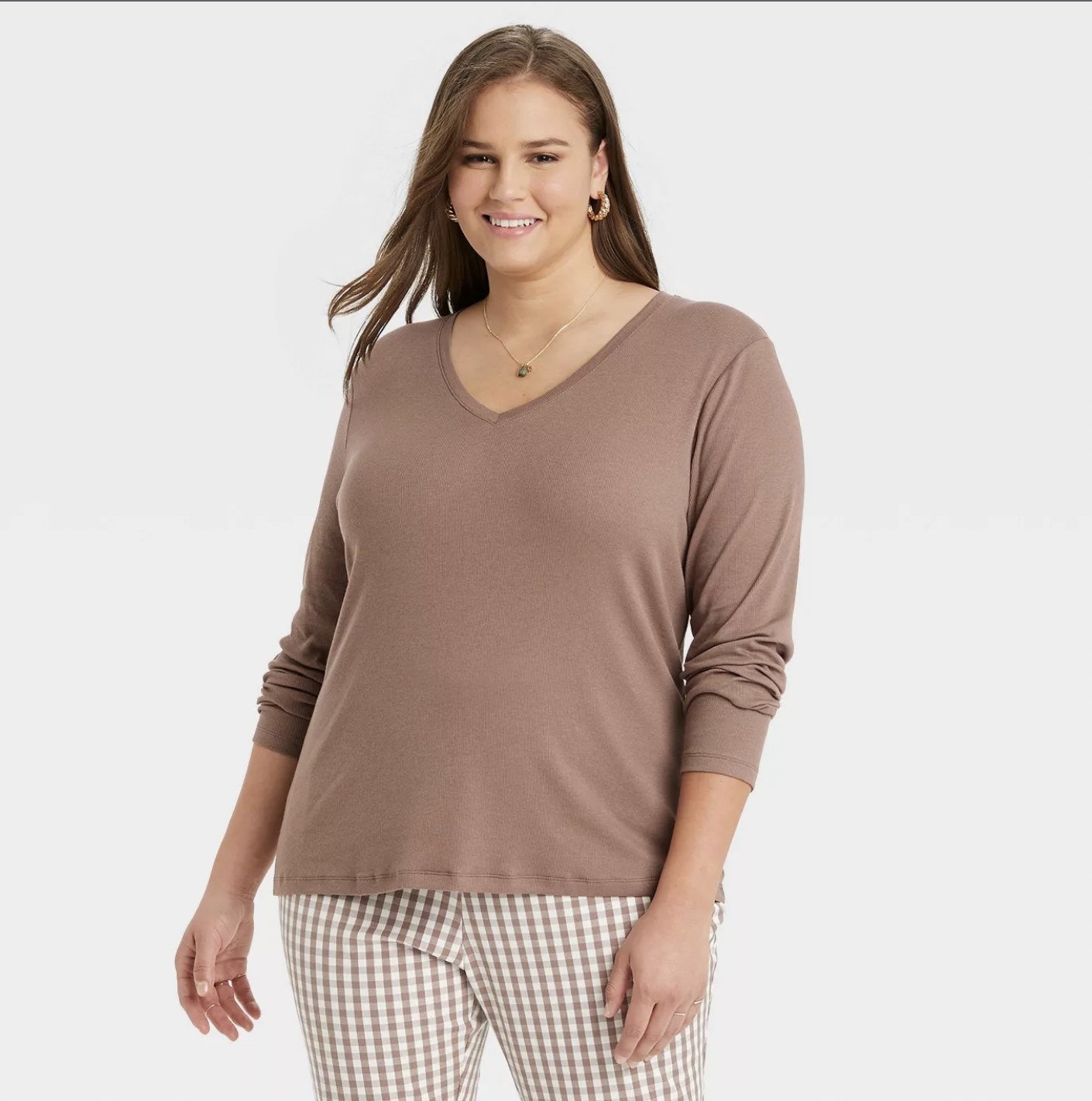 a model in a V-neck long sleeve tan top