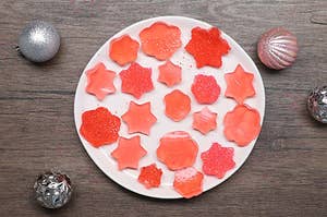 An overhead shot of a plate with Red Sparkling Dessert Bites on a plate in different shapes.