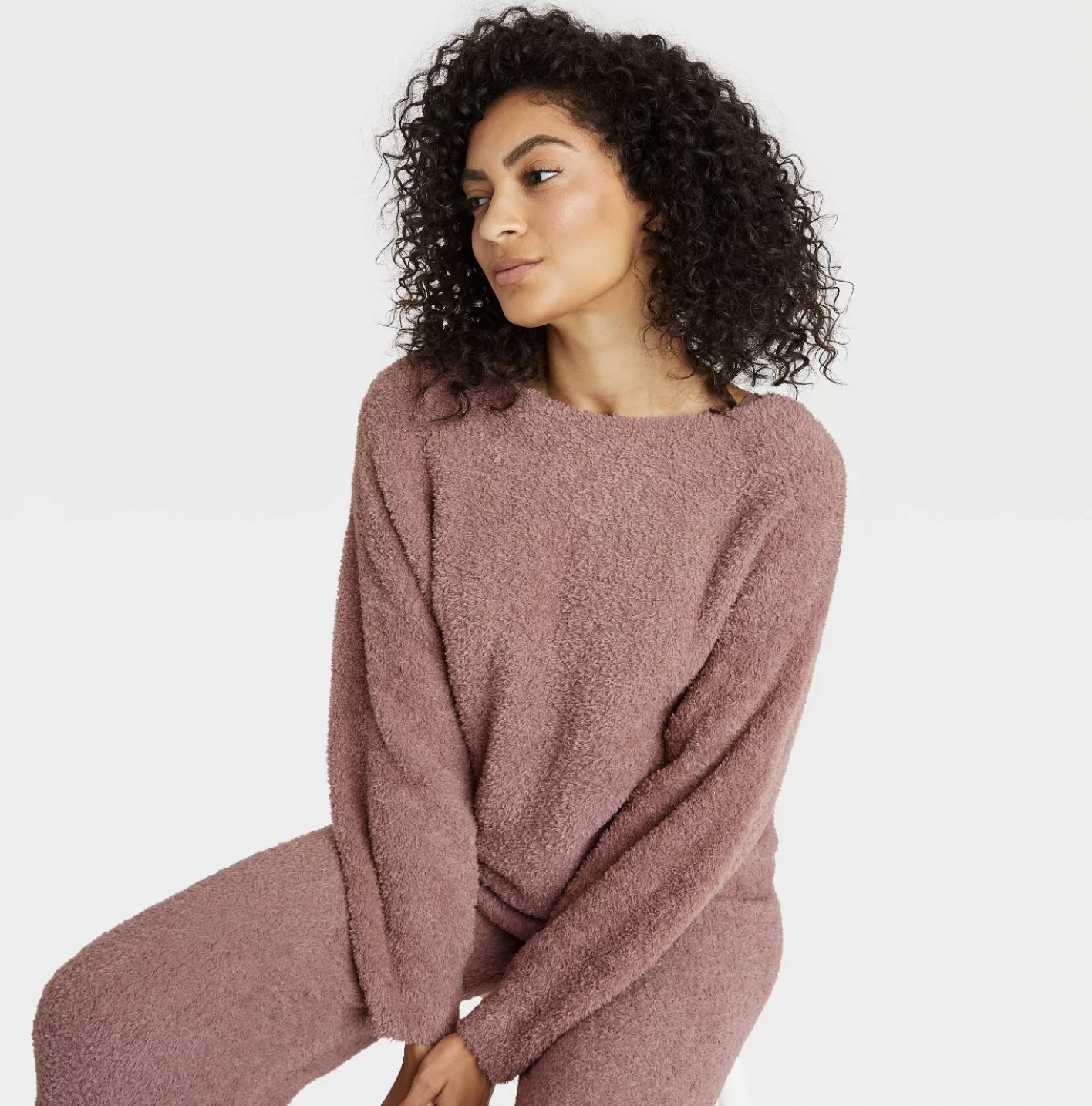 a model in a fuzzy pink sweatshirt