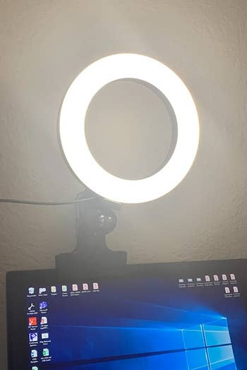 a reviewer photo of the illuminated light clipped on the top of a laptop screen