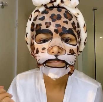 A reviewer wearing the leopard face mask
