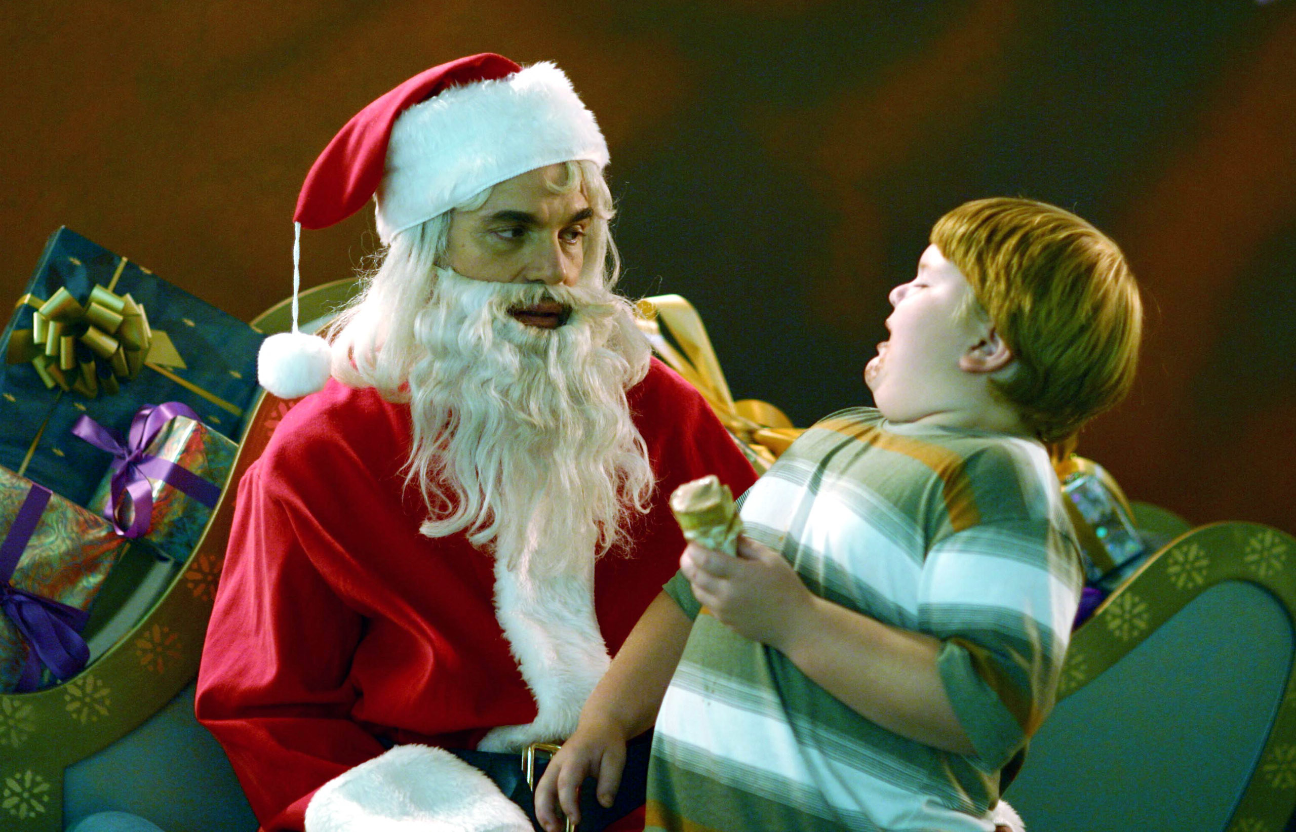A miserable-looking Santa with a kid on his lap
