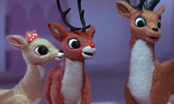 Three reindeer, including Rudolph, look happy outside