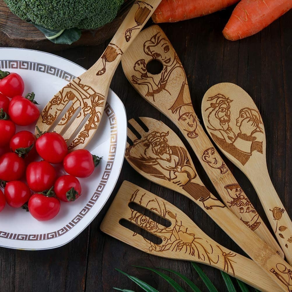 The five utensil pieces with Beauty and the Beast characters etched into them