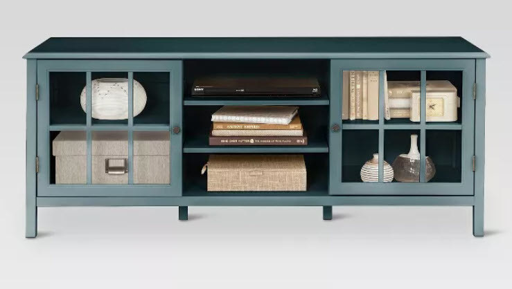 A dark teal covered TV stand with glass window-style doors on each side of a 3-story middle shelf. Comes with adjustable shelves and pull out handles. Wooden-finish.