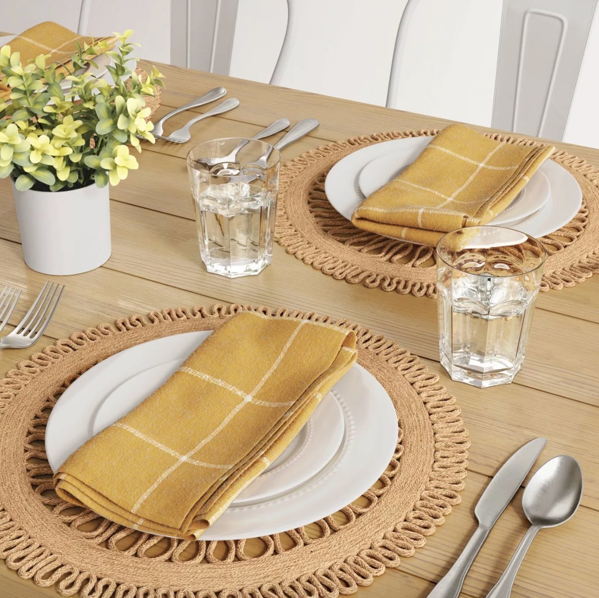natural woven jute placemat on a dining table with plates, napkins, and silverware