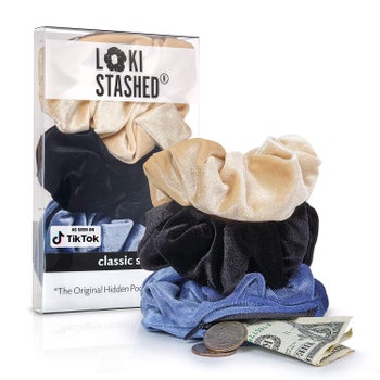 The tan, black, and blue scrunchies stacked on top of one another, with some money coming out of the zip-up pocket on the bottom one