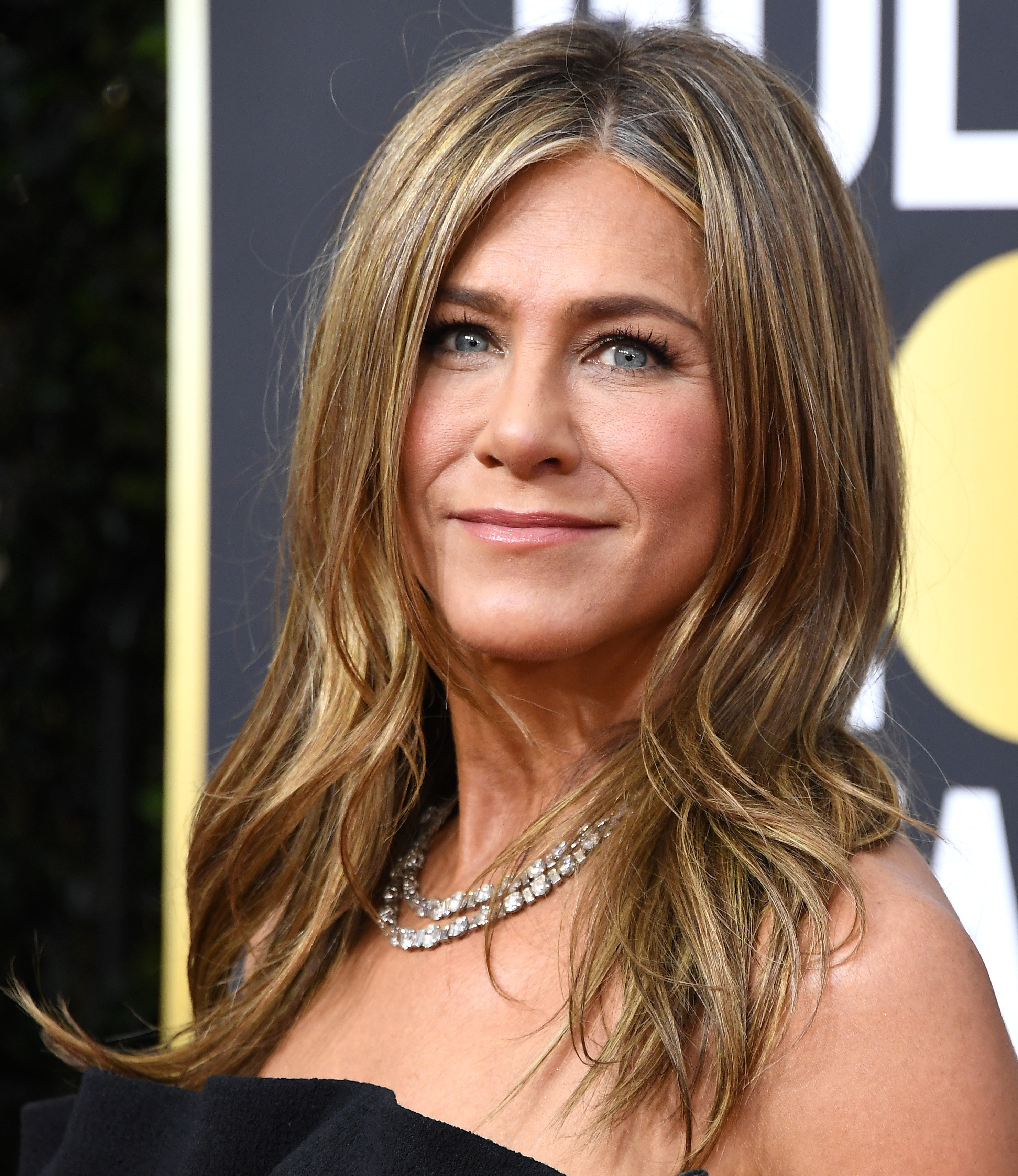 Aniston smiles at the camera while at a red carpet event