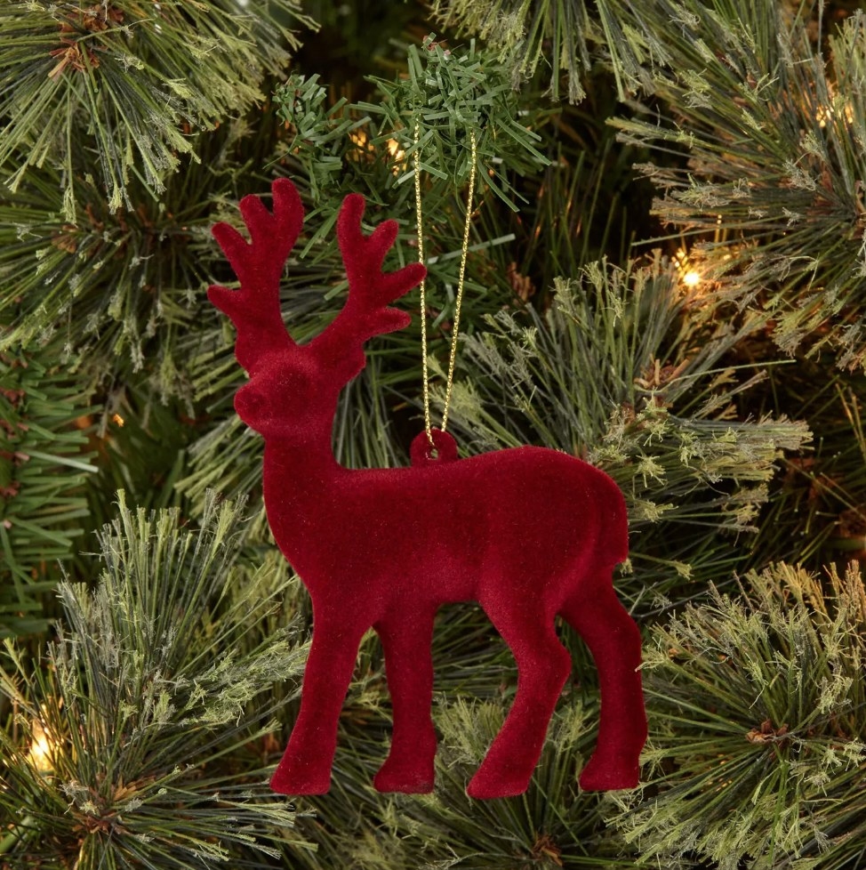 Close up of red velvet reindeer ornament on tree