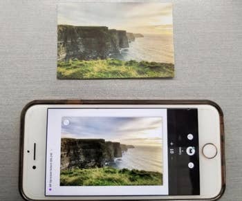 the printed photo next to the photo on a persons iphone
