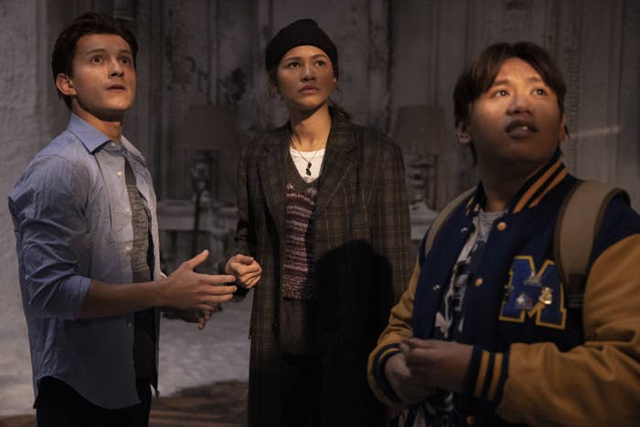 All three actors look up as they stand in a room in a scene from the film