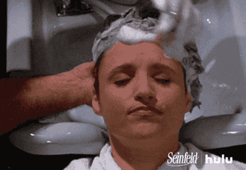 A woman getting her head massaged with shampoo at a salon