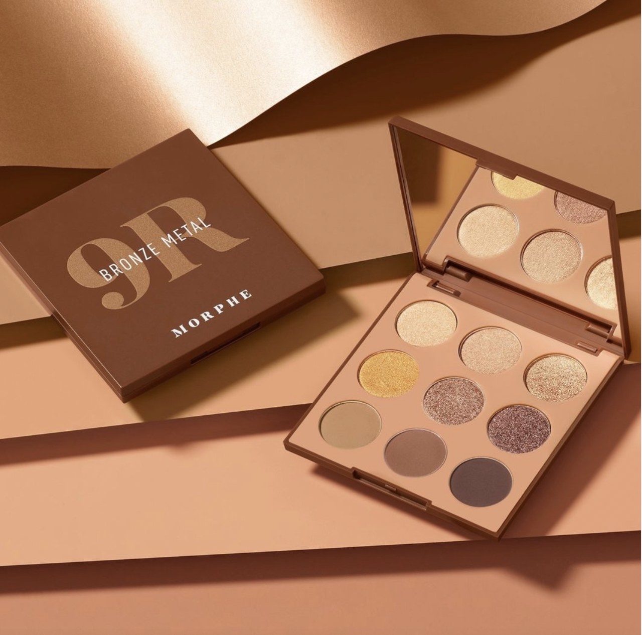 An eyeshadow palette with gold, brown, and copper shades