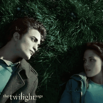 Edward and Bella laying on the grass together