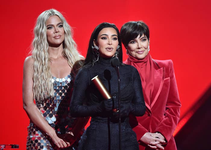 Khloe stands on stage with Kris and Kim