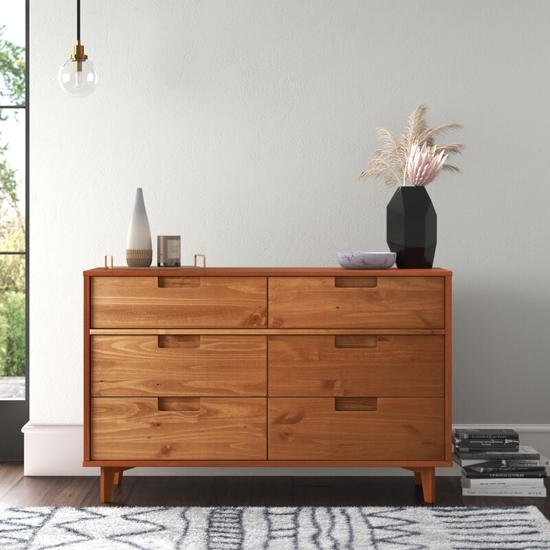 caramel colored six drawer double dresser in a room