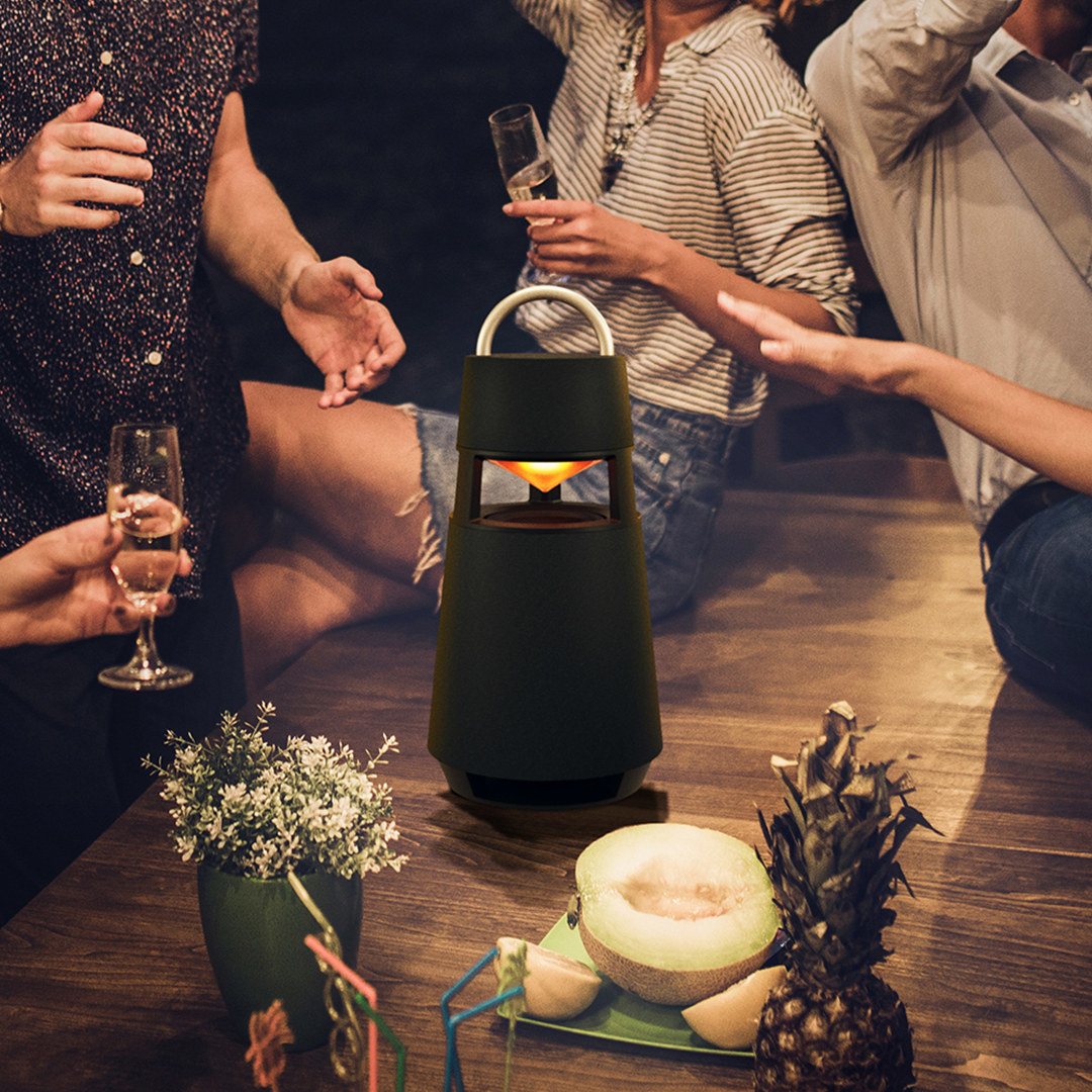 the speaker on a table surrounded by people at a party