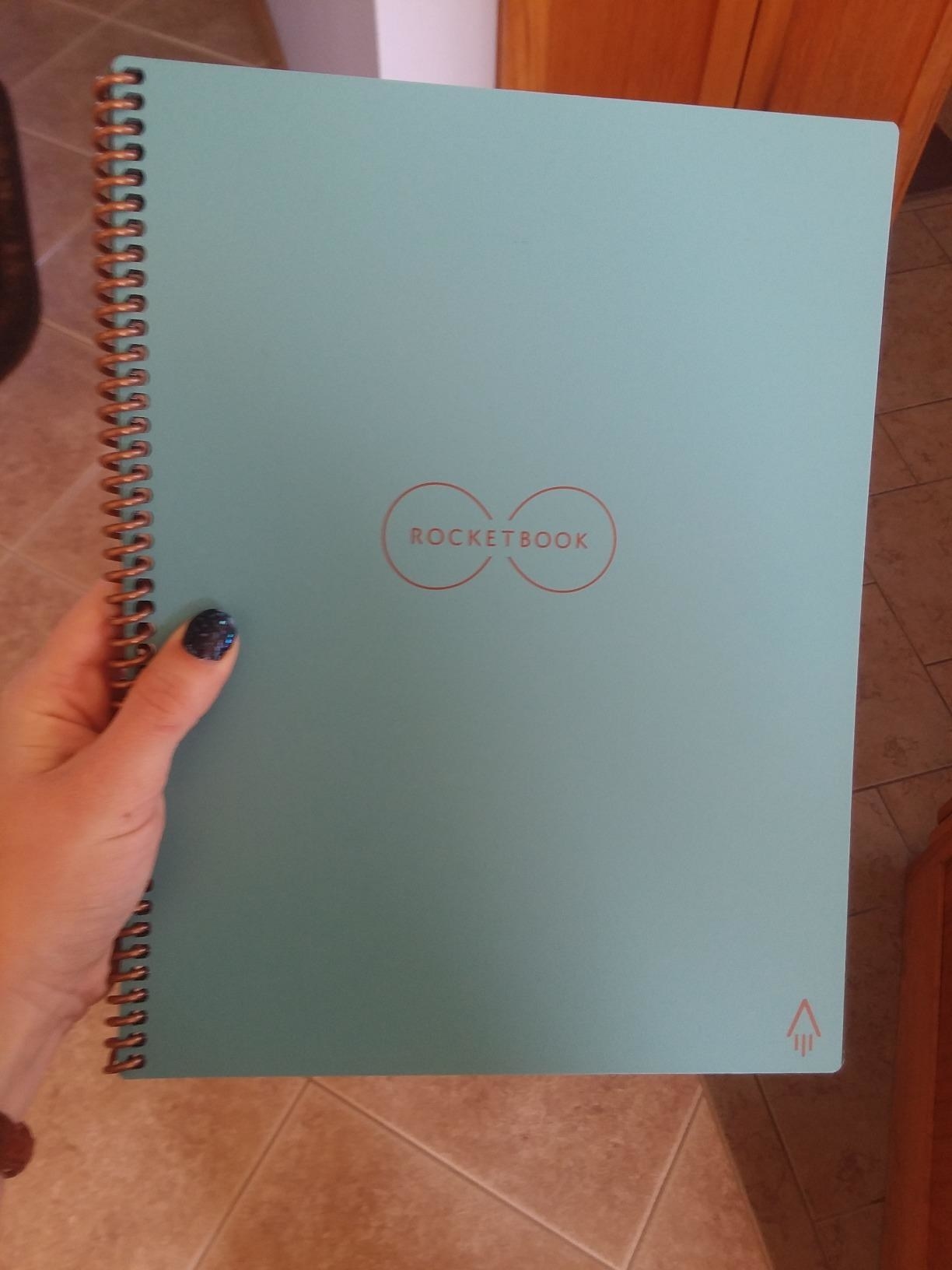 a reviewer shows the blue spiral notebook