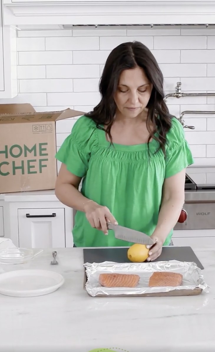 Woman preparing a salmon dish from her Home Chef meal delivery kit