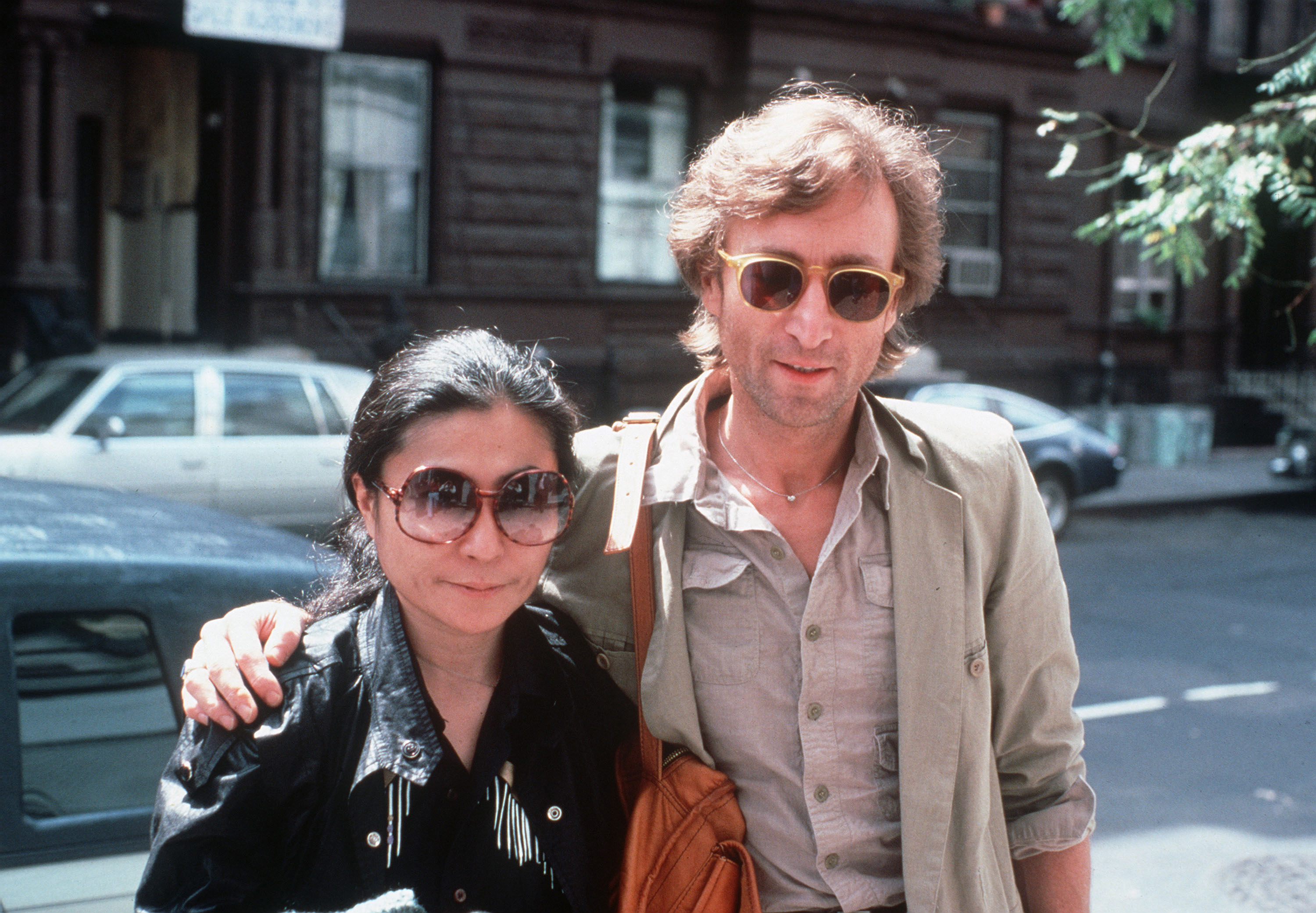 John Lennon and Yoko Ono  in sunglasses on a sunny day, new york city street