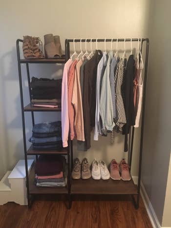 reviewer's brown and black closet rack with clothes and shoes on it