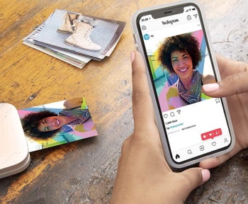 Someone using the portable printer to print out a photo from their phone