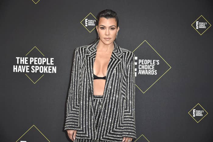 Kourtney in an open stripped blazer and matching pants on the red carpet of the People&#x27;s Choice Awards
