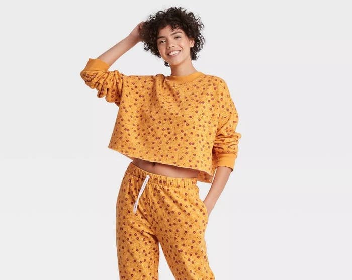 A model wearing a cropped yellow floral crewneck sweatshirt