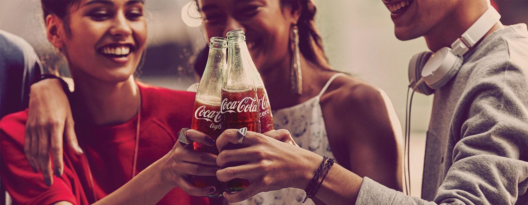 A group of people doing cheers with Coca-Cola.