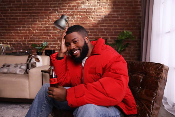 Khalid smiling with a bottle of Coca-Cola