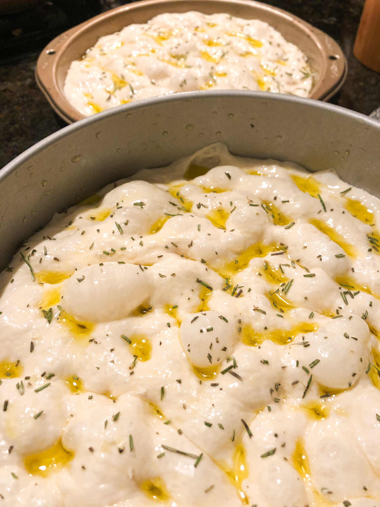 Focaccia dimpled with olive oil and herbs, before baking